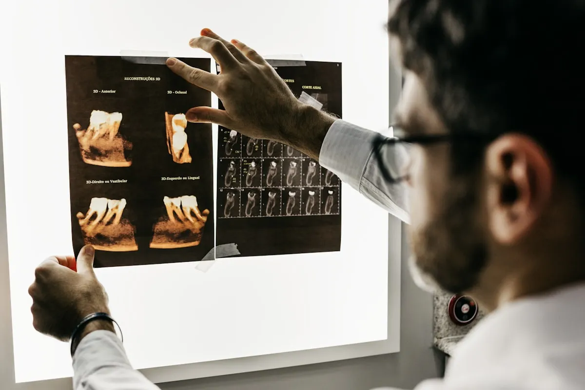 Tandarts bespreekt 3D-röntgenbeelden van een gebit op een lichtbak