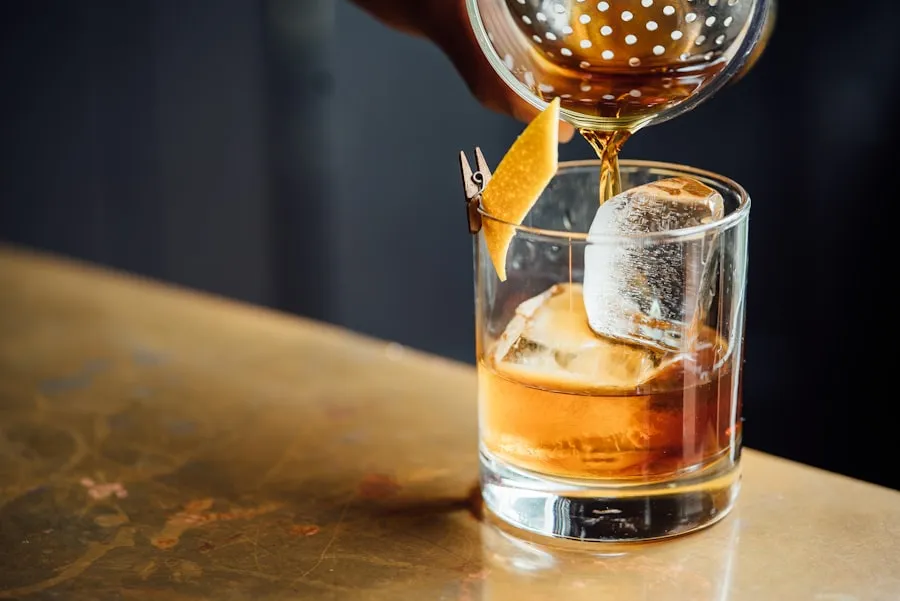 Whisky die over een groot ijsblok in een glas wordt geschonken