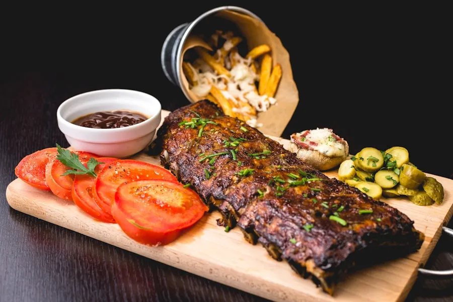 Gegrilde bavette met tomaat, augurk en frietjes op een houten plank