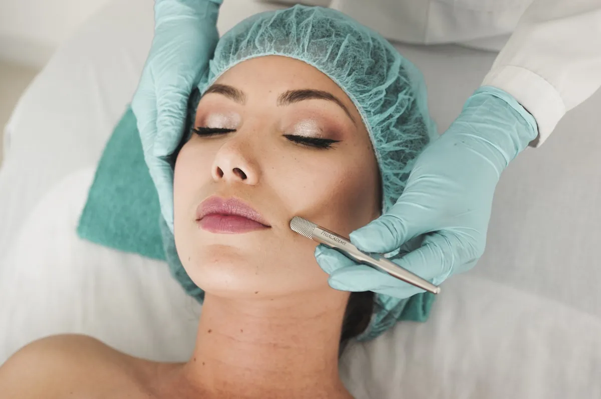 Huidspecialist met handschoenen voert geconcentreerd een dermaplaning-behandeling uit bij een klant