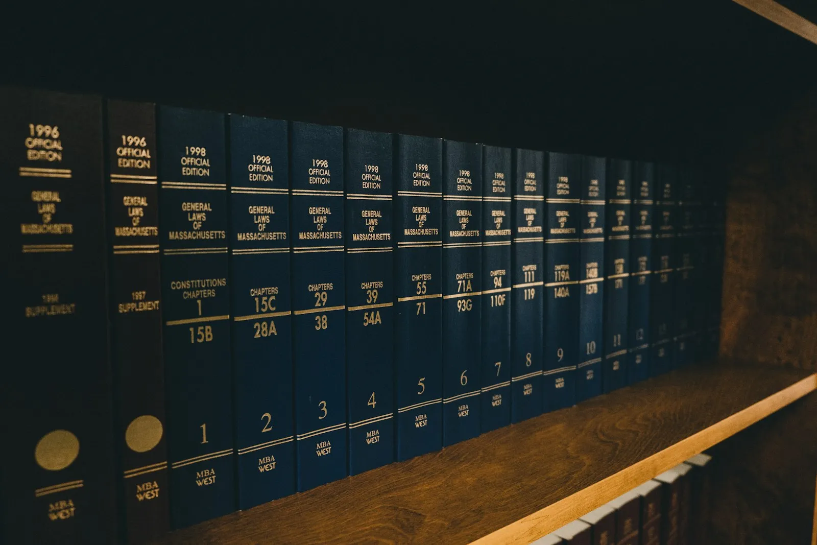 De kantoorbibliotheek van Reehorst & Cornelissen: rijen donkerblauwe wetboeken met gouden belettering op een houten plank