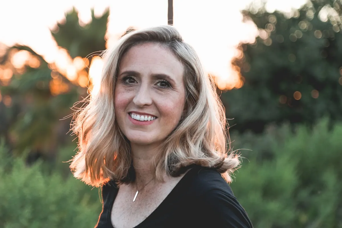 Vrouw aan het eind van een lange dag, buiten in het avondlicht — het moment vóór een behandeling